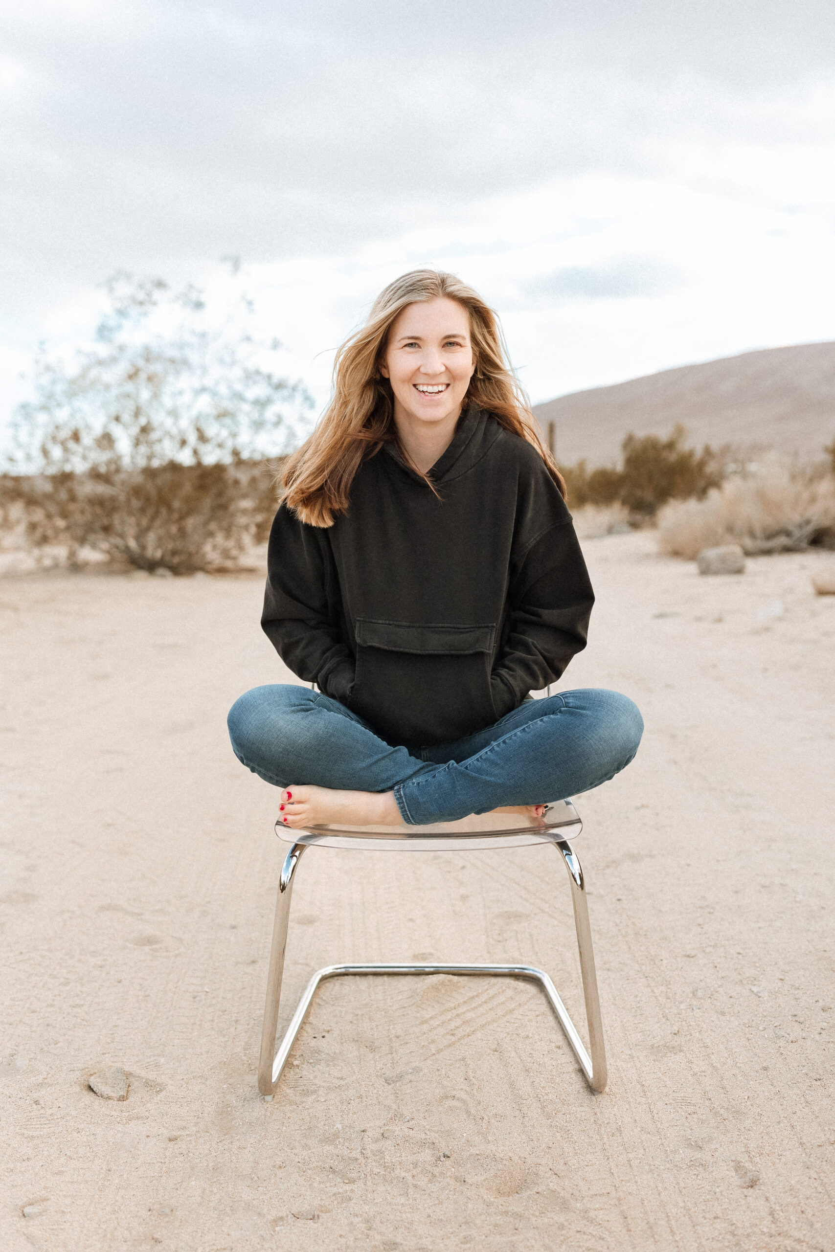Photography business growth coach sitting on a chair in the desert